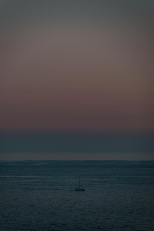 Ein-Boot-fährt-in-den-Hafen-bei-Sonnenuntergang