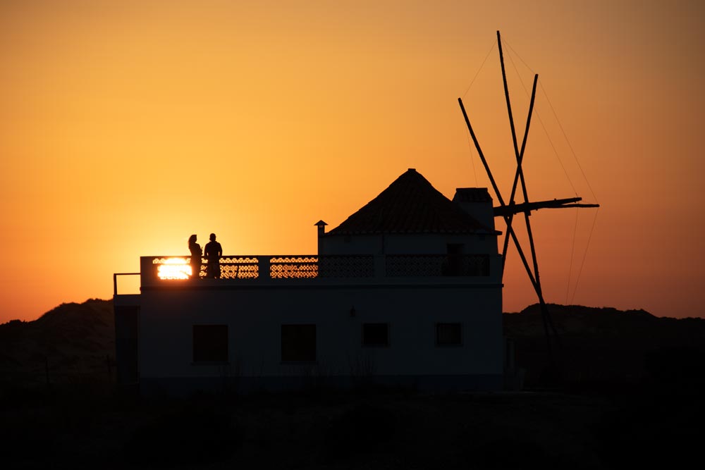 Ein Paar genießt den Sonnenuntergang von einer Mühle auf dem Fischerweg